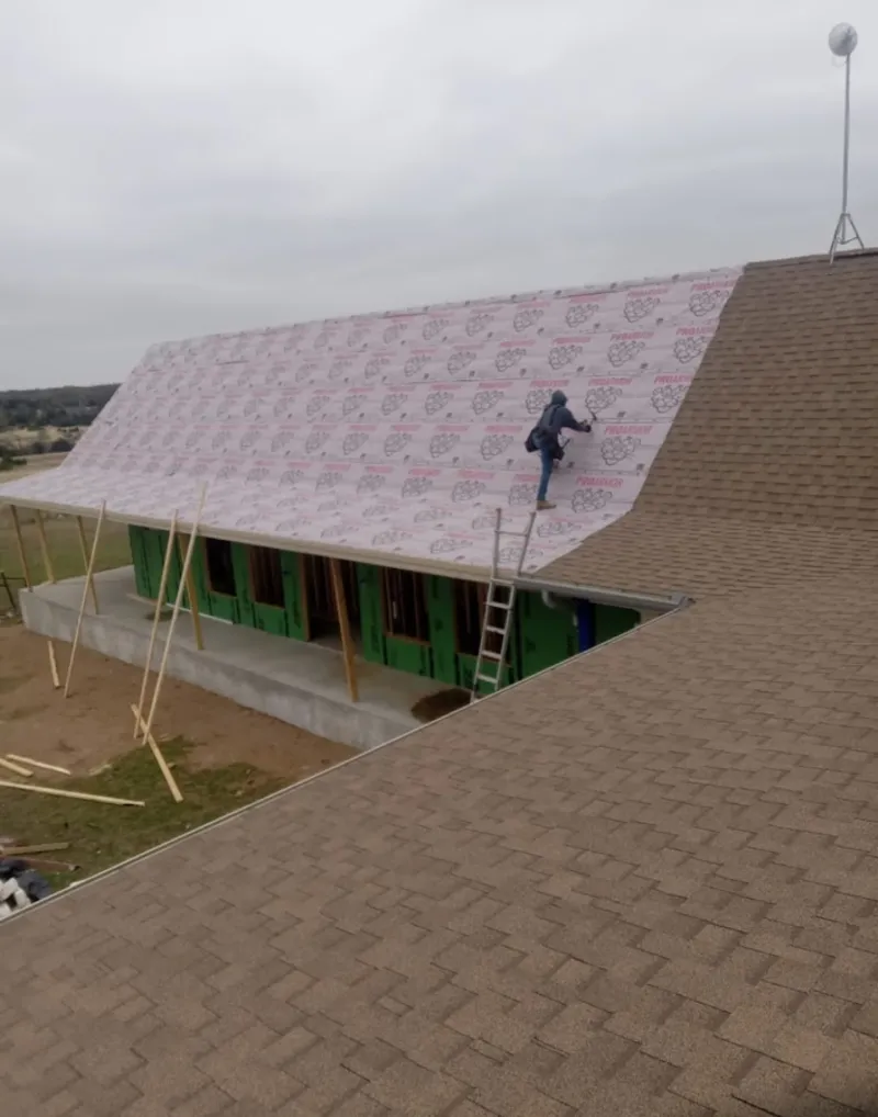 Worker preparing underlayment for a metal roof installation in Jonesboro